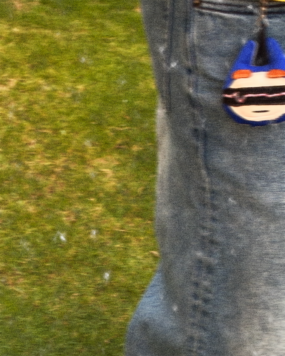 Black sneakers and the blue keychain on textured grass